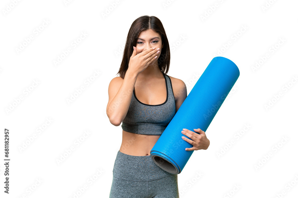 Young sport woman going to yoga classes while holding a mat over isolated chroma key background happy and smiling covering mouth with hand Young sport woman going to yoga classes while holding a mat over isolated chroma key background happy and smiling covering mouth with hand
