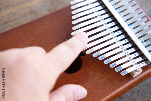 Female hand touches metal plates of kalimba, African percussion musical instrument class lamellaphones or plucked reed idiophones, Music therapy photo