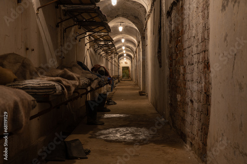A long, gloomy hallway in an old military base with rows of beds lining the wall