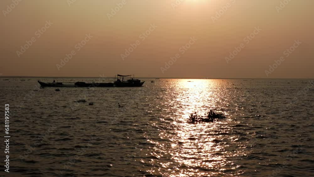 A cargo boat is moving on the Padma River at sunset. Evening river view of golden water. A cargo boat is moving on the Padma River at sunset. Evening river view of golden water.