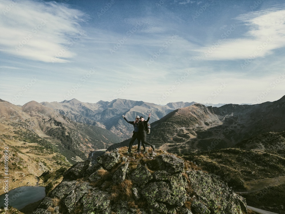 a couple of people standing on top of a mountain above mountains: Andorra, Pyrenees a couple of people standing on top of a mountain above mountains: Andorra, Pyrenees