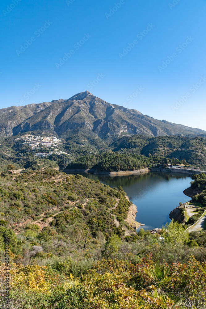a portrait image of the reservoir and dam found behind the town of Marbella in Andalucia 