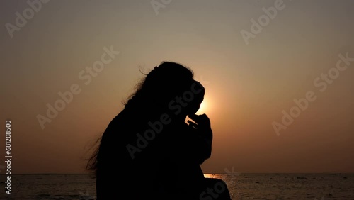 An Asian mother and her child are enjoying the evening river view at sunset time. Silhouette view of a mom and kid having fun. A child with parents on holiday conceptual 4k video. photo