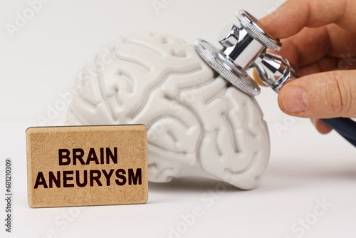 Using a stethoscope, the brain is diagnosed, next to it is a sign with the inscription - Brain aneurysm
