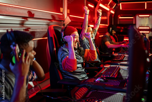 Professional gamer team celebrating victory raising hands photo