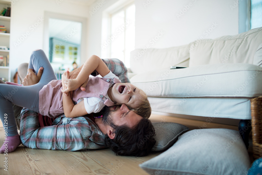 Father playing with little daughter at home
