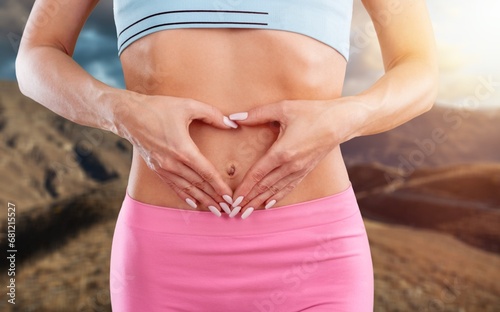 Young fitness female hold hands on stomach