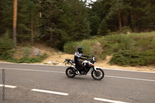 black-clad motorcyclist on motorcycle on the road with helmet on, driving at high speed
