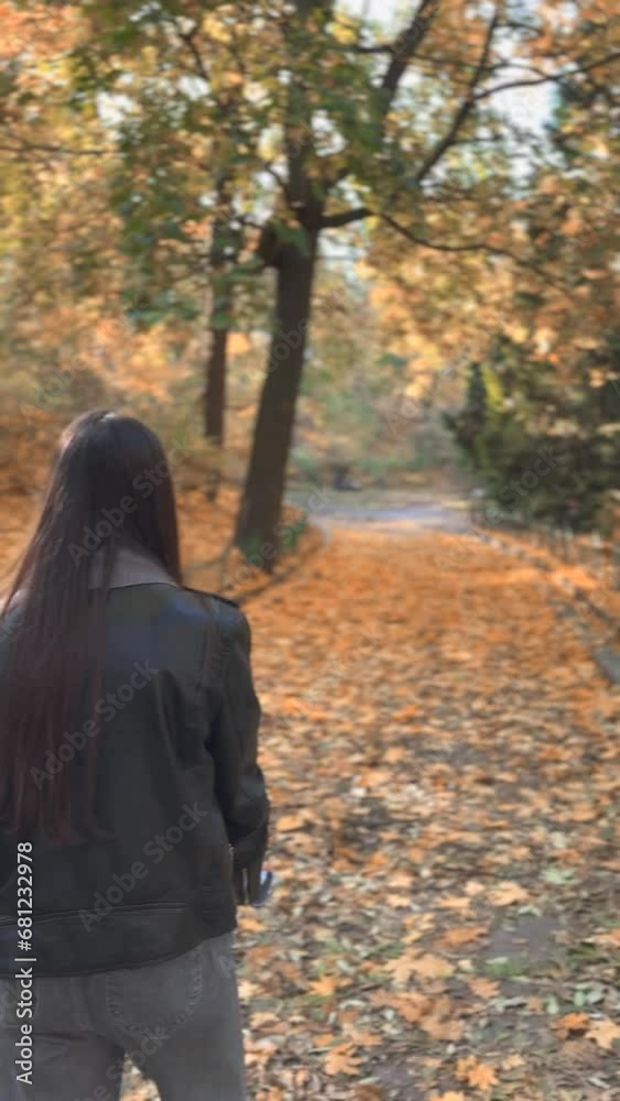 Autumn park stroll, capturing shots from behind the young woman. Autumn park stroll, capturing shots from behind the young woman.