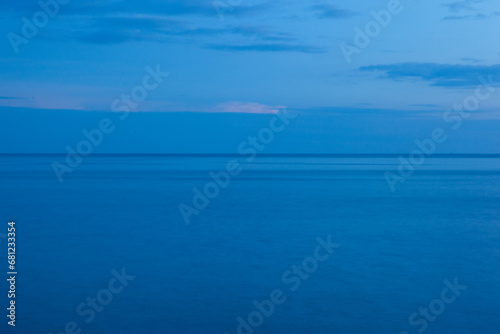 Calm seascape with horizon line. Blue sea background after sunset for publication, design, poster, calendar, post, screensaver, wallpaper, postcard, banner, cover, website. High quality photo