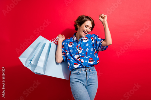 Photo of dancing carefree youth girl eve party xmas party atmosphere prepared already bought gifts bags isolated on red color background