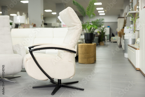 Comfortable ergonomic modern soft office chair with white suede and leather upholstery, black metal armrests and chair base, displayed for sale in furniture store photo