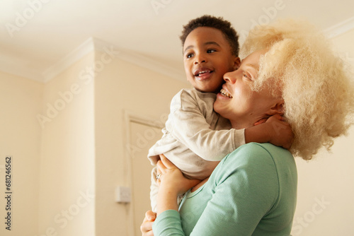 Obraz na plátne Young woman with albinism playing and laughing with son in living room