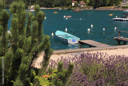Wooden boat in the lake seen from the deck, surrounded by lavender flowers