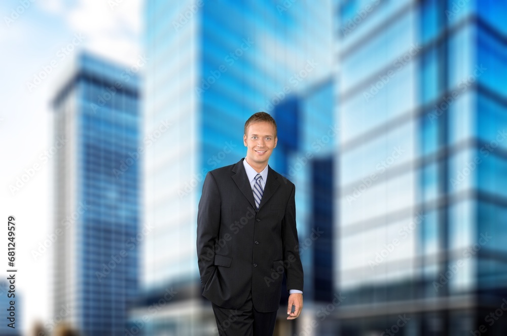 Young happy businessman standing in city street Young happy businessman standing in city street
