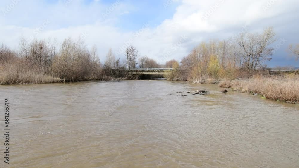 The dark waters of the river flow into the waters of a large lake. The waves collide with each other. The dark waters of the river flow into the waters of a large lake. The waves collide with each other.