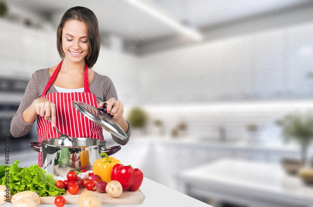 Beautiful young female preparing food at home.