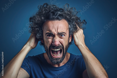 Upset boy, man in blue t shirt screaming and crying with opened mouth and closed eyes against