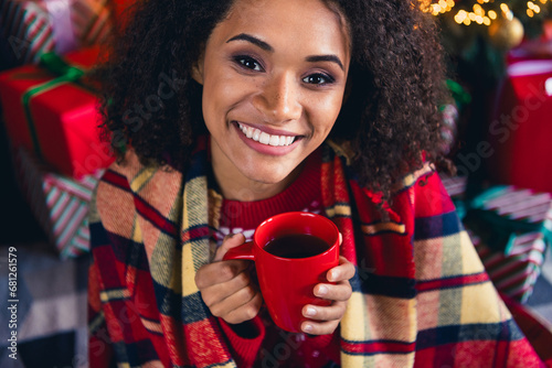 Photo of cheerful jolly dreamy girl wear wrapped in warm plaid hold hot tasty tea enjoy relax rest christmas morning season indoors