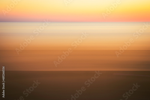 Romantic foggy motion blur sunset or sunrise landscape for soft warm-toned pastel seascape backgrounds