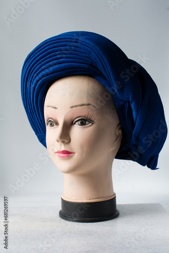 Blue turban on a mannequin head, pleated blue fashion turban on a white background