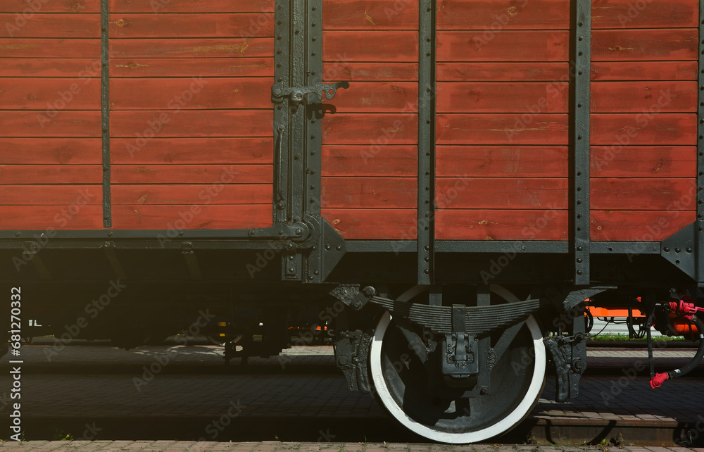 The side of the old brown wooden freight car with the wheel of the times of the Soviet Union