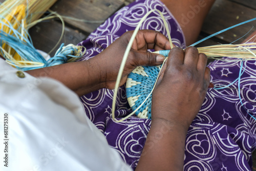 African woman hand making, weaving a basket with a pretty pattern, using grasses and natural dyes in Botswana, Africa