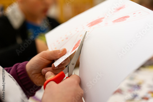 A child cuts a piece of paper with scissors