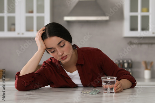 Carta da parati Depressed woman with glass of water and antidepressant pills at white marble tab
