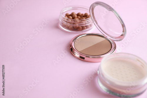 Different face powders on pink background, space for text