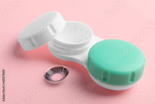 Case with color contact lenses on pink background, closeup