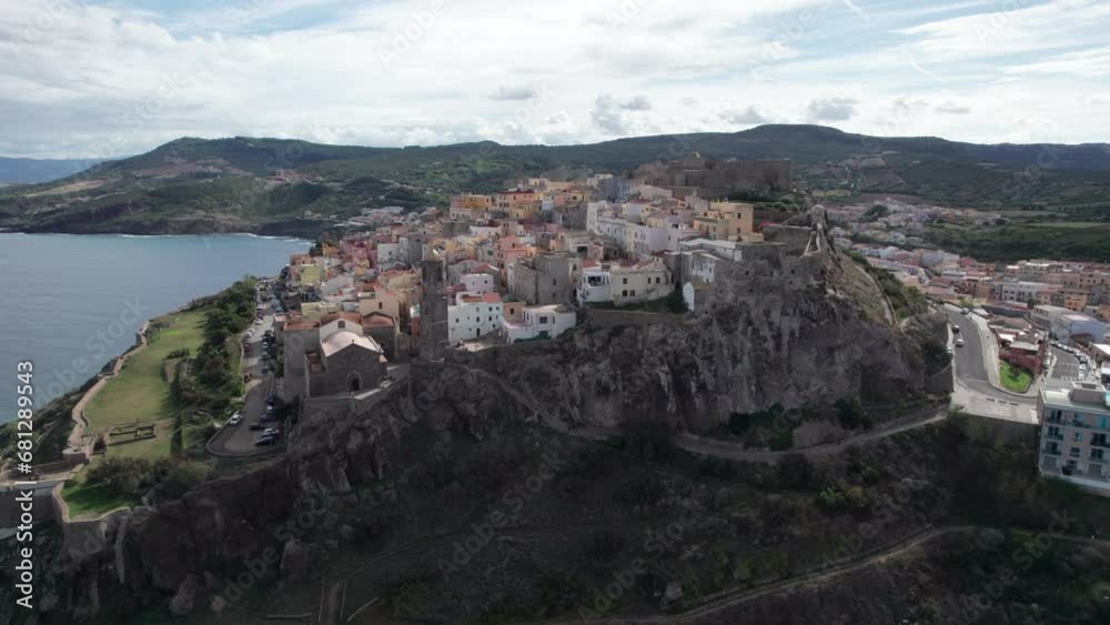 city of Castelsardo, Certeña: flying towards this impressive city built on a mountain and with its colorful houses and historic tower. city of Castelsardo, Certeña: flying towards this impressive city built on a mountain and with its colorful houses and historic tower.
