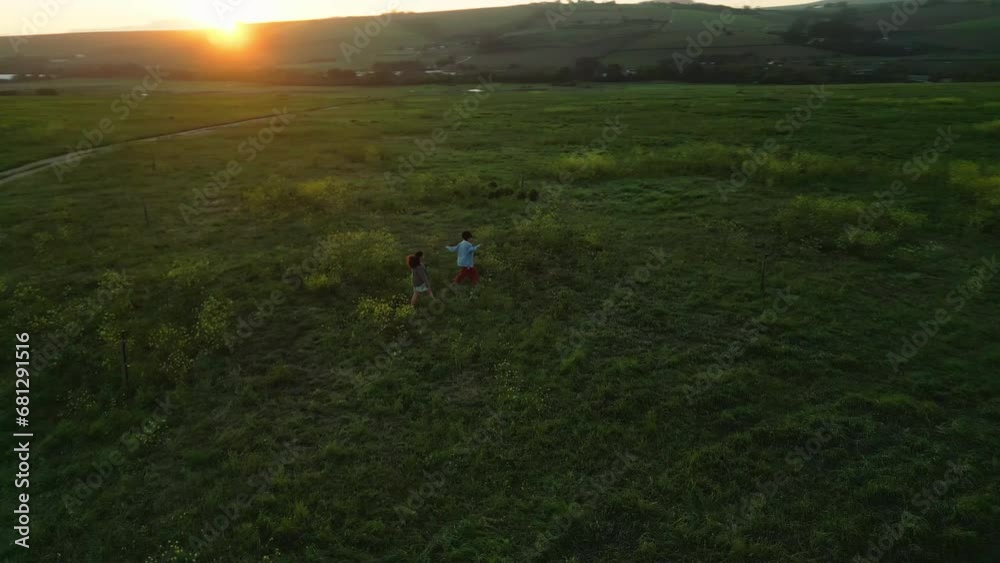 Above, flowers and friends running in a field for freedom in nature on outdoor holiday or vacation in spring. Countryside, drone and people relax with peace and fun on a farm in the morning landscape Above, flowers and friends running in a field for freedom in nature on outdoor holiday or vacation in spring. Countryside, drone and people relax with peace and fun on a farm in the morning landscape