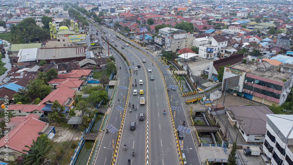 The long flyover in Banjarmasin is passed by many cars and motorbikes