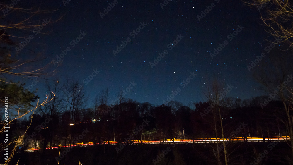 Fototapeta premium Vehicle Light Streaks by a Side of a Hill at Night, Baltic, Ohio