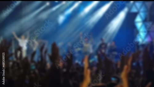 Defocused Abstract Background of Cheering concert crowd with colorful stage light, silhouette of Large group of people audience at live music festival photo
