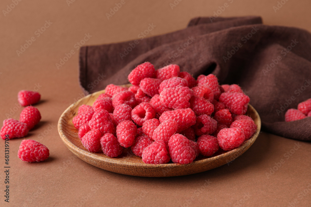 Plate with fresh raspberries on brown background Plate with fresh raspberries on brown background