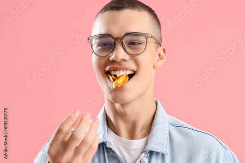Young man eating french fri...