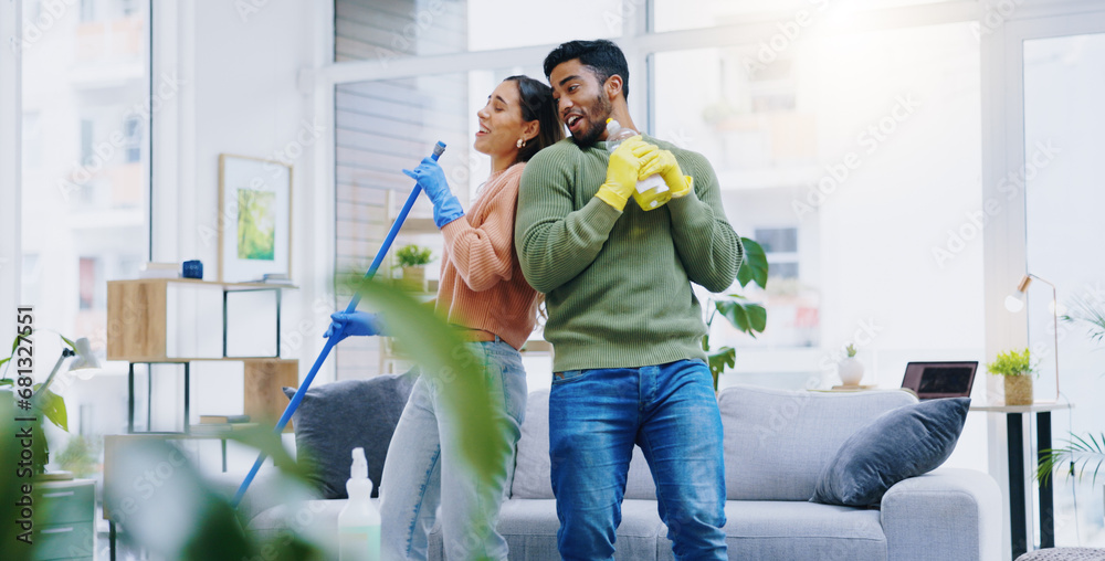 Happy couple, dancing and singing while cleaning living room together for fun disinfection or hygiene at home. Man and woman enjoying housekeeping, germ and bacteria removal in lounge at house - obrazy, fototapety, plakaty 