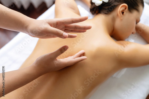 Closeup woman customer enjoying relaxing anti-stress spa massage and pampering with beauty skin recreation leisure in day light ambient salon spa at luxury resort or hotel. Quiescent