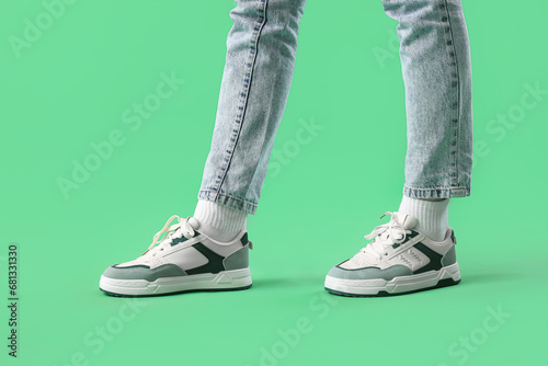 Wallpaper Mural Legs of young woman in stylish sneakers on green background Torontodigital.ca