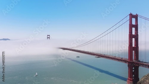 Drone shot of Golden Gate Bridge traffic in morning fog, San Francisco, California, USA. Aerial view of cars driving into thick misty cloud on red suspension bridge. Foggy landscape , 4k footage  photo