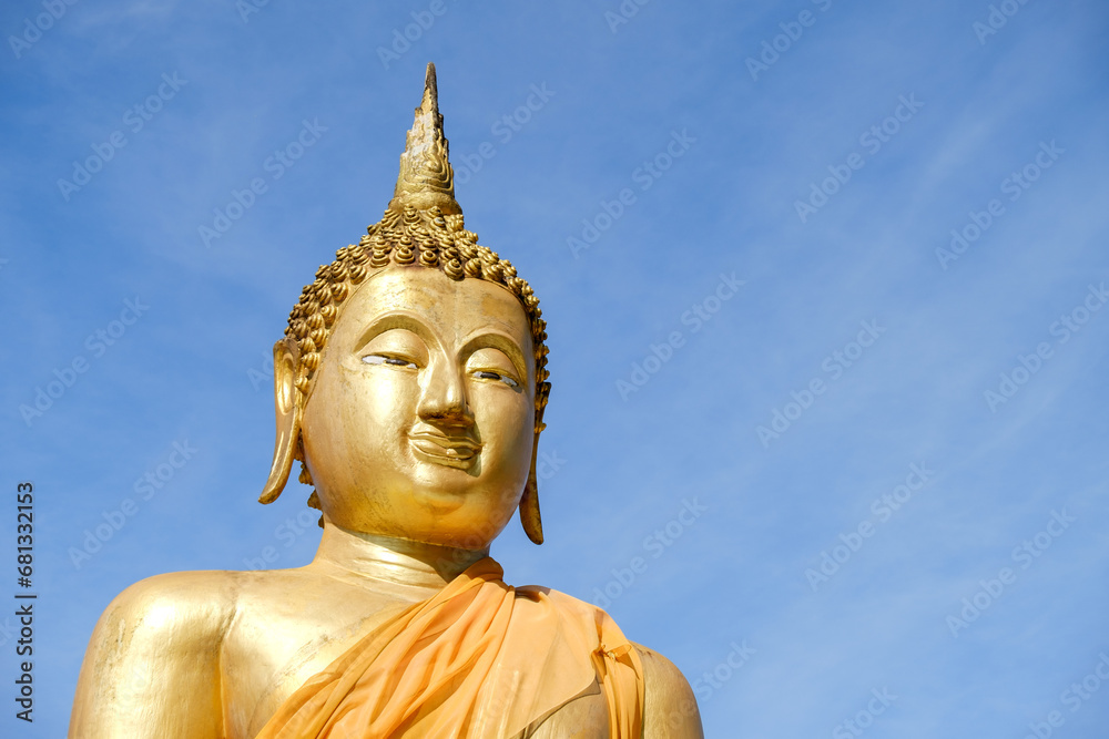Golden Buddha statue on a clear sky background