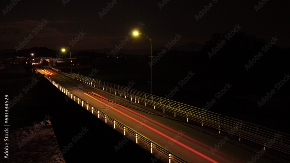 外灯のある橋に車の光跡