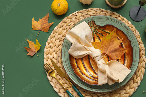 Autumn table setting with leaves on green background