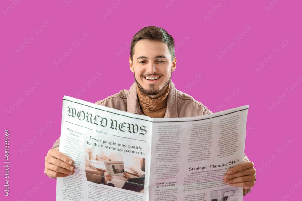 Young man reading newspaper on purple background Young man reading newspaper on purple background