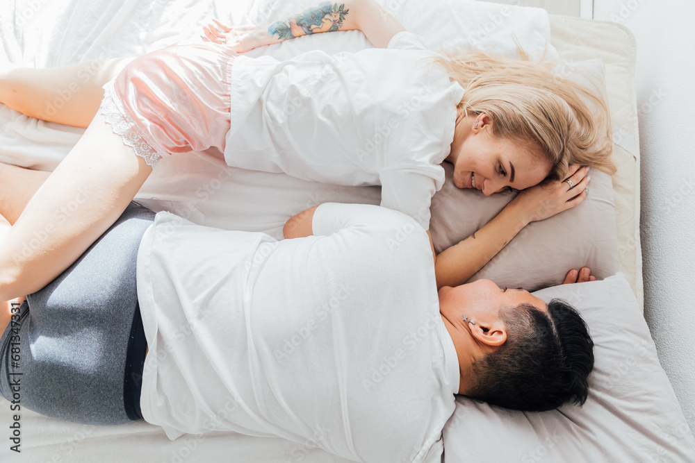 a man and a woman in love lie in bed in the morning in the bedroom a man and a woman in love lie in bed in the morning in the bedroom