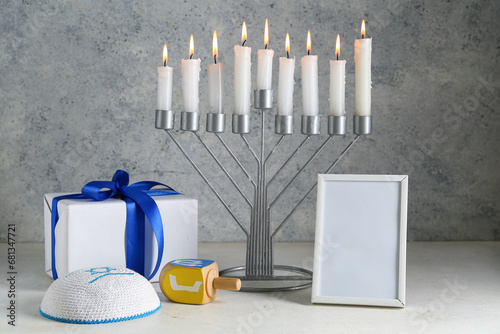 Menorah, blank picture frame, gift and Hanukkah symbols on grunge background photo