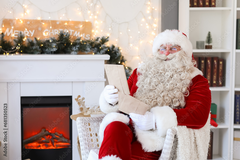 Fototapeta premium Santa Claus with letters at home on Christmas eve