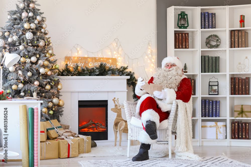 Fototapeta premium Santa Claus with letters at home on Christmas eve